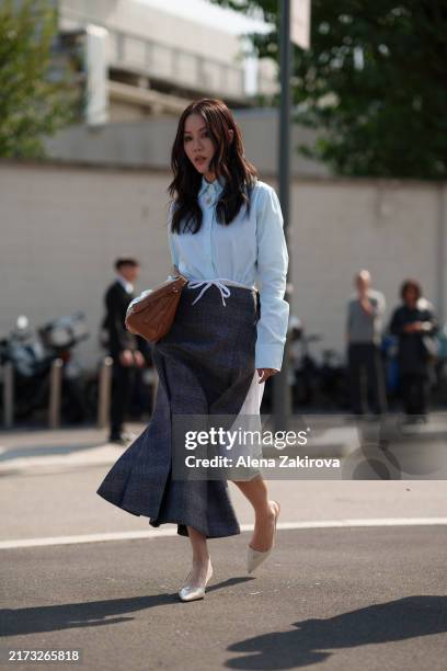 Jenny Tsang wearing a light blue shirt, a denim and white skirt, a bag is seen outside the Prada show during the Milan Fashion Week Menswear...