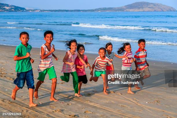 group of vietnamese children on the beach, vietnam - sydostasiatisk kultur bildbanksfoton och bilder