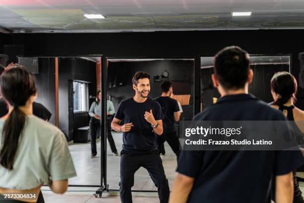 teacher and students rehearsing in a dance studio - latin american dancing stock pictures, royalty-free photos & images