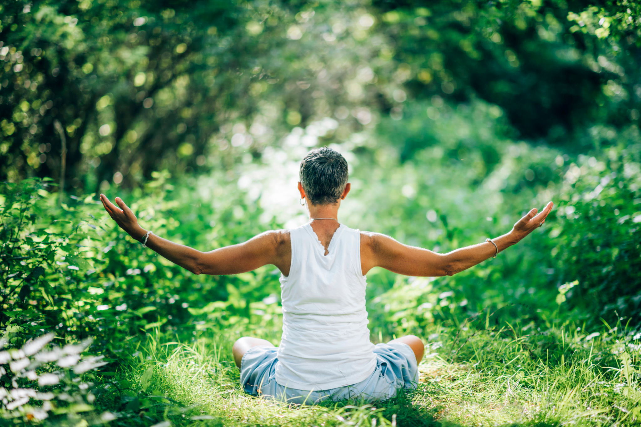 Inner Peace Meditation. Mindful Woman Meditating With Open Arms, Sitting On The Ground Inner Peace Meditation. Mindful Woman Meditating With Open Arms, Sitting On The Ground
