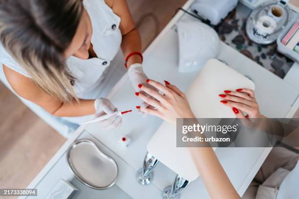 young woman getting her nails done at a beauty salon - manicureset stockfoto's en -beelden