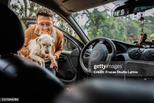 young man getting into the car with dog - dog pound stock pictures, royalty-free photos & images