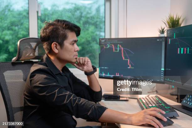 stock trader analyzing market trends on multiple screens - multiple screens stock pictures, royalty-free photos & images