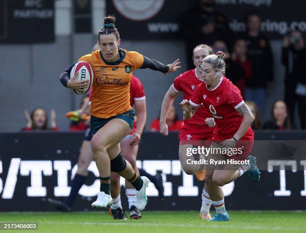 Maya Stewart of Australia breaks past Keira Bevan of Wales as she runs in to scores her team's first try during the Women's International Test Match...