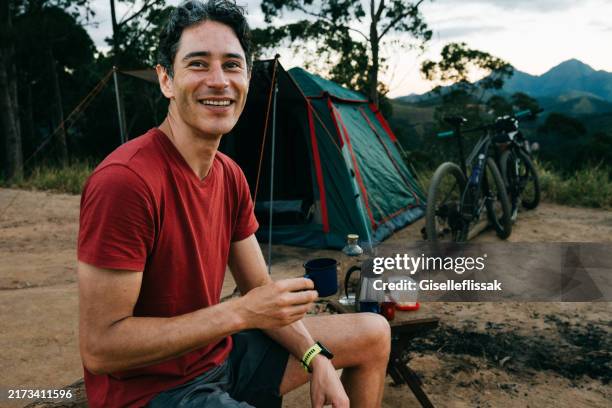 portrait d’un jeune homme souriant, campant et regardant la caméra - activité de plein air photos et images de collection