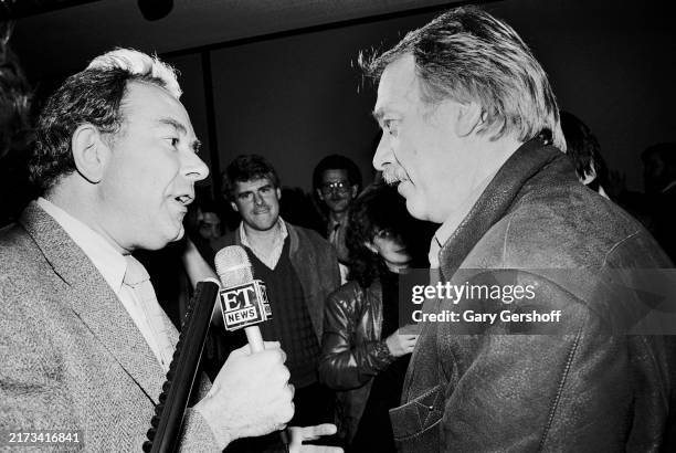 British-American Entertainment Tonight journalist Robin Leach interviews American actor Howard Hesseman during a press party for the release of the...