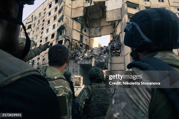 Military personnel look at the destroyed house following an air strike, on September 24, 2024 in Kharkiv, Ukraine. Several projectiles struck...