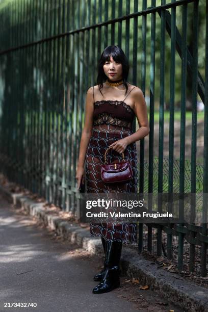 Susie Lau wears a light blue and burgundy printed midi dress, black leather boots and a Gucci bamboo burgundy leather bag outside Gucci show during...