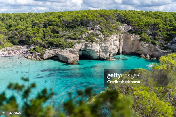 beautiful bay amgong green woods, cala mitjana, menorca, spain - menorca stockfoto's en -beelden