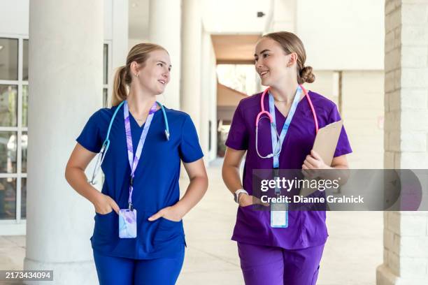 enfermeras jóvenes hablando en el pasillo de un hospital - vestimenta de hospital fotografías e imágenes de stock