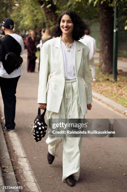 Guest wears white shirt, mint green blazer and pants and black bag with white dots outside Gucci show during the Milan Fashion Week Spring/Summer...