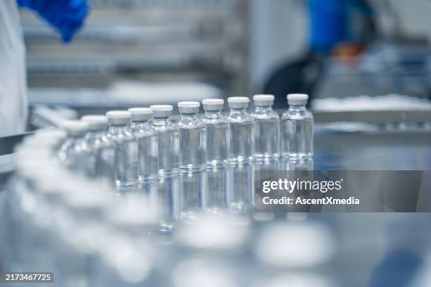 bottles on a conveyor belt at a pharmaceutical bottle manufacturing plant - packaging manufacturing stock pictures, royalty-free photos & images
