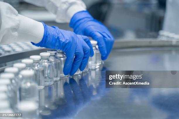 détail des mains travaillant dans une usine pharmaceutique - biologie photos et images de collection
