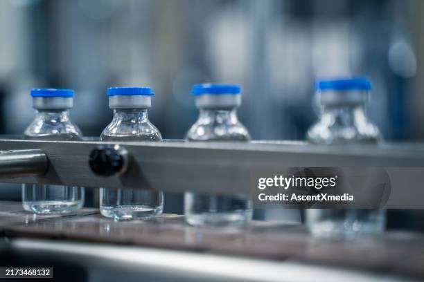 bottles on a conveyor belt at a pharmaceutical bottle manufacturing plant - pharmaceutical industry stock pictures, royalty-free photos & images