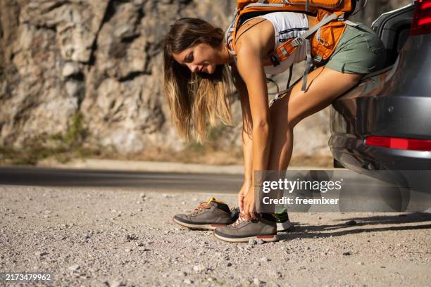 giovane donna che si prepara per l'escursione in montagna - stringa foto e immagini stock