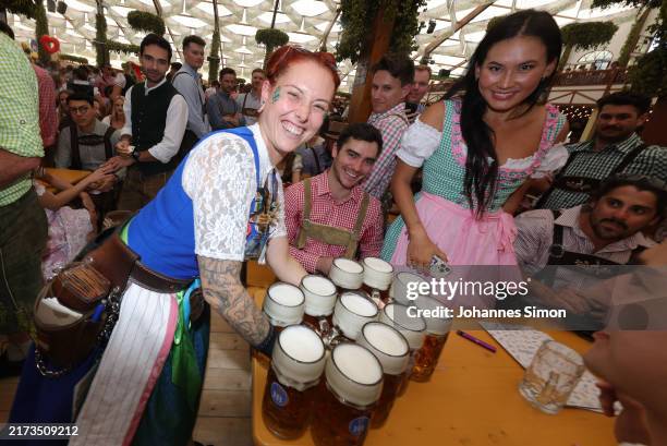 Waitress carries beer mugs inside the Hofbraeuhaus beer tent on the opening day of the 2024 Munich Oktoberfest, Munich's annual beer festival, on...