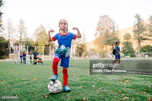 portrait of a young six-year-old girl soccer player on the field, football - coragem imagens e fotografias de stock