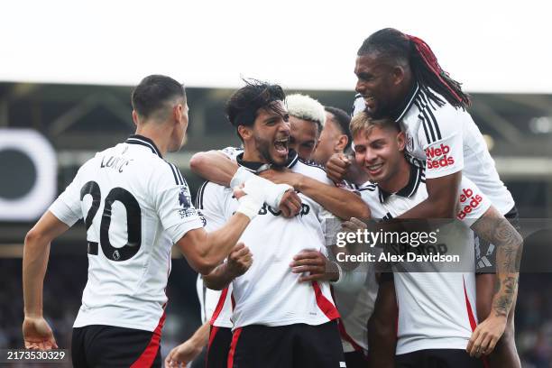 Raul Jimenez of Fulham celebrates with his team mates after scoring his team's first goal during the Premier League match between Fulham FC and...