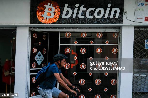 Man rides a bicycle past a store advertising Bitcoin ATMs in Nicosia on September 25, 2024.