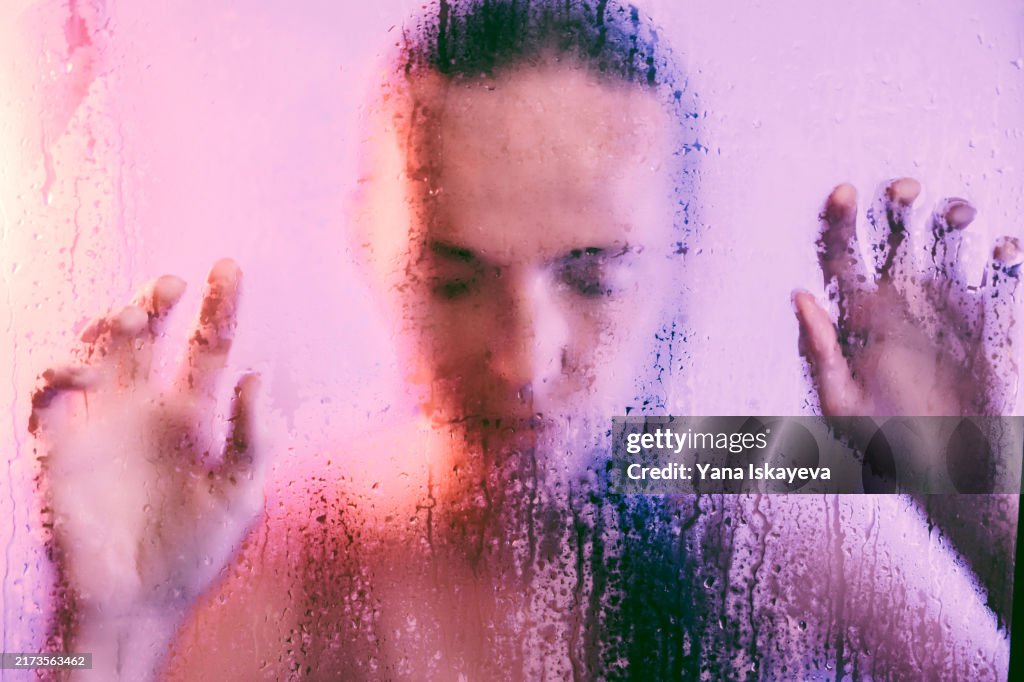 A sad woman in the shower, going through an emotional period of life