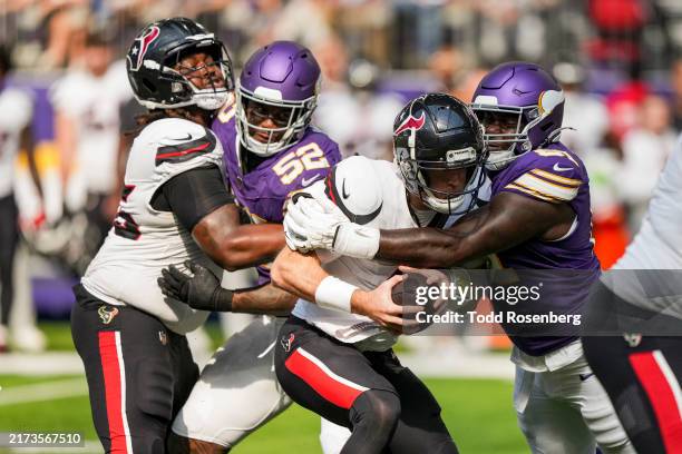 Quarterback Davis Mills of the Houston Texans is sacked by defensive tackle Jalen Redmond of the Minnesota Vikings during the fourth quarter of an...