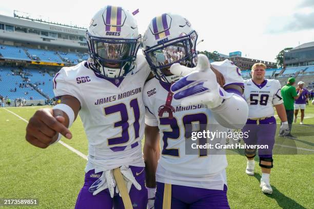 Antoine Booth and Tyler Brown of the James Madison Dukes celebrate as they leave the field after a win against the North Carolina Tar Heels at Kenan...