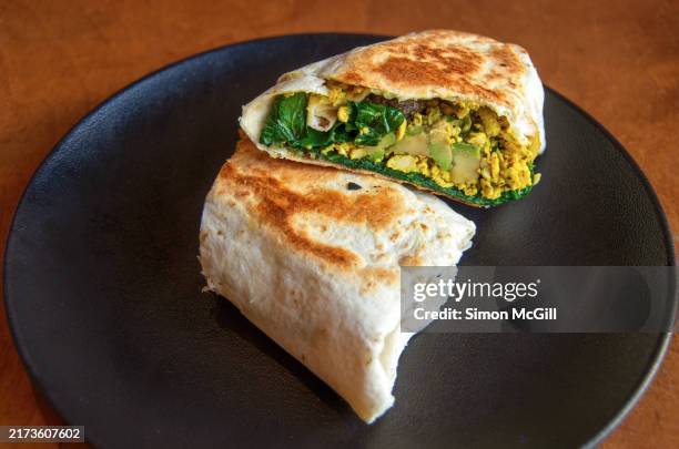 toasted flour tortilla wrap sandwich with herbed tofu scramble, roasted mushroom, avocado, spinach & tomato relish - spinach tortilla stock pictures, royalty-free photos & images