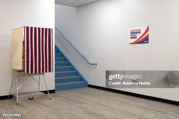 Sign reads "election heroes work here" near a mock polling booth at Runbeck Election Services on September 25, 2024 in Phoenix, Arizona. The company...