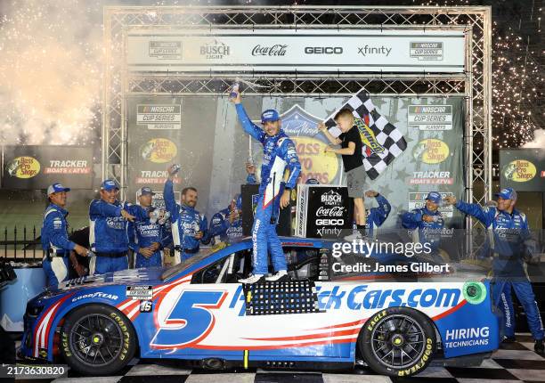 Kyle Larson, driver of the HendrickCars.com Chevrolet, celebrates with his son, Owen Larson in victory lane after winning the NASCAR Cup Series Bass...