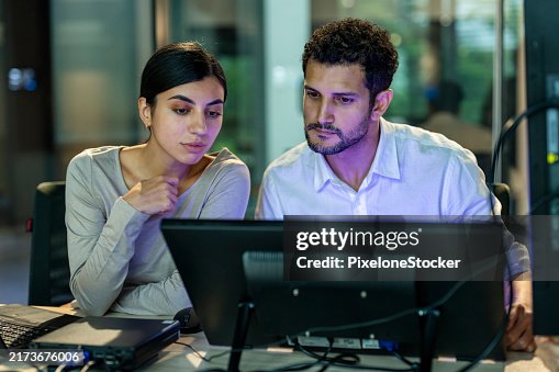 Two software developers checking programming code on computer screen. Two software developers checking programming code on computer screen.