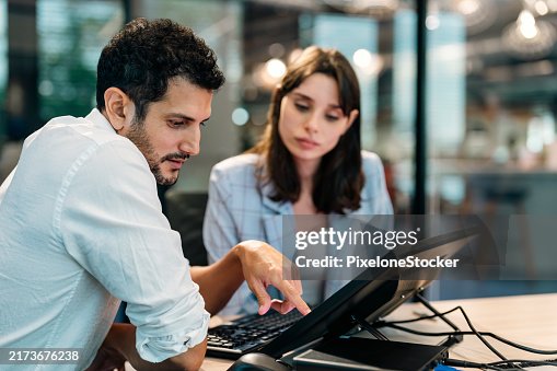 Two software developers checking programming code on computer screen. Two software developers checking programming code on computer screen.