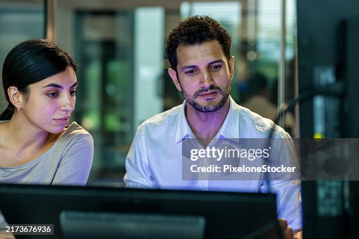 Two software developers checking programming code on computer screen. Two software developers checking programming code on computer screen.