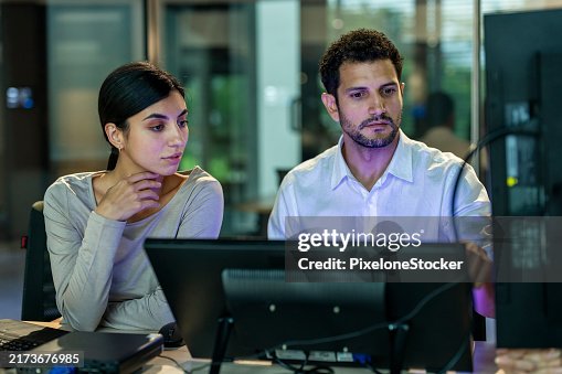 Two software developers checking programming code on computer screen. Two software developers checking programming code on computer screen.