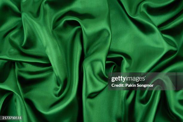 full frame shot of green silk cloth with soft folds texture. - velvet stock pictures, royalty-free photos & images