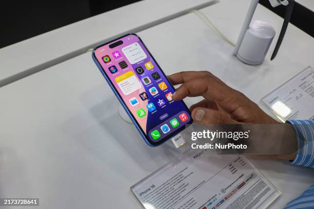 Customer checks Apple's latest iPhone 16 series displayed for sale at Master Arts Shop in Srinagar, Jammu and Kashmir, on September 26, 2024....