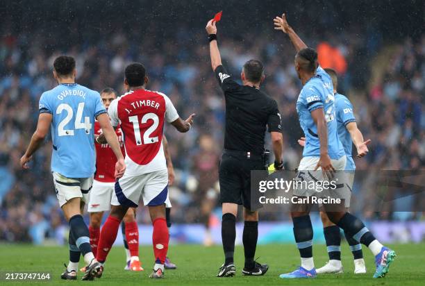 Players react as Referee, Michael Oliver shows a red card to Leandro Trossard of Arsenal during the Premier League match between Manchester City FC...