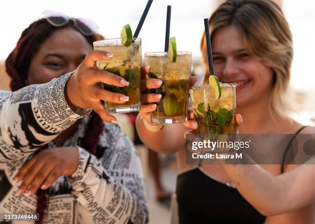 tre, giovani donne, brindare, con, cocktail, celebrare, amicizia - caipirinha foto e immagini stock