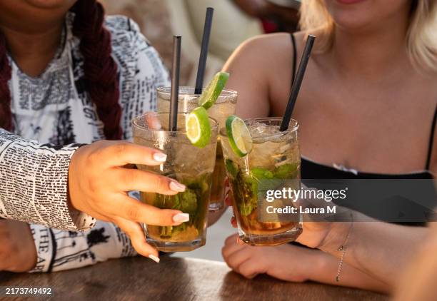 friends toasting cocktails celebrating friendship at bar - cachaça stock pictures, royalty-free photos & images