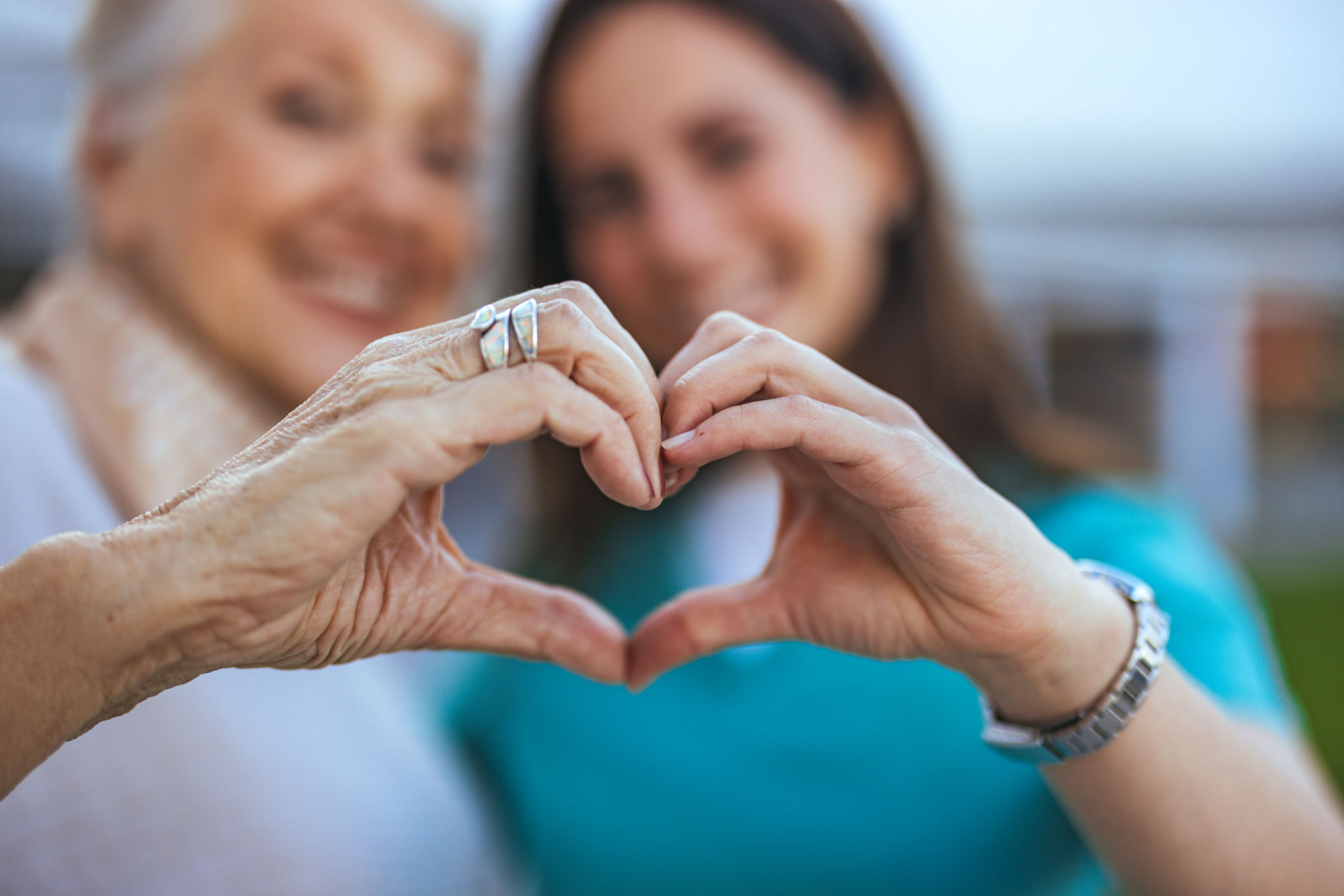 Elderly Woman and Caregiver Forming Heart Shape with Hands Elderly Woman and Caregiver Forming Heart Shape with Hands