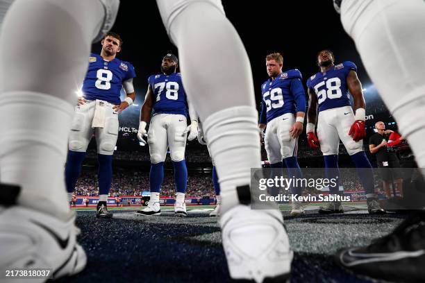 Daniel Jones, Andrew Thomas, Casey Kreiter, and Bobby Okereke of the New York Giants stand at midfield for the coin toss prior to an NFL football...