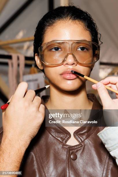 Make up artist works on a model backstage at the Andreadamo fashion show during the Milan Womenswear Spring/Summer 2025 on September 22, 2024 in...