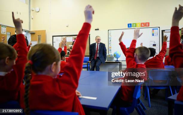 Britain's Prime Minister Keir Starmer speaks with pupils at Holy Cross Catholic Primary School during a visit on September 23, 2024 in Liverpool,...
