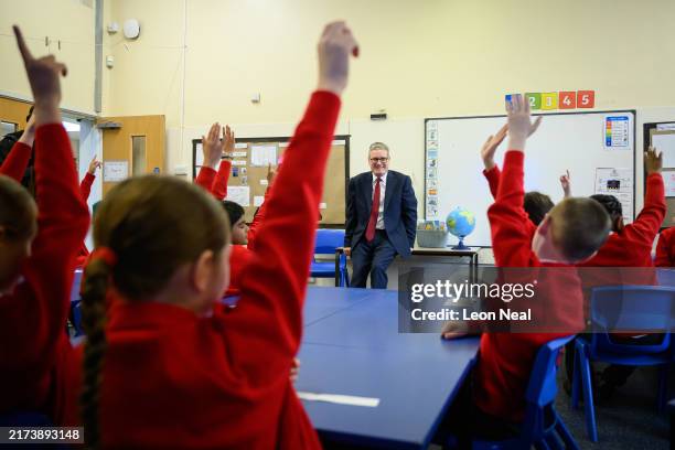 Britain's Prime Minister Keir Starmer speaks with pupils at Holy Cross Catholic Primary School during a visit on September 23, 2024 in Liverpool,...