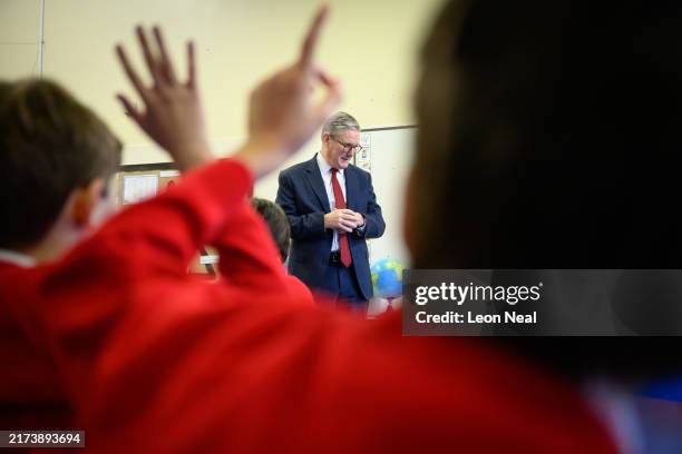 Britain's Prime Minister Keir Starmer speaks with pupils at Holy Cross Catholic Primary School during a visit on September 23, 2024 in Liverpool,...