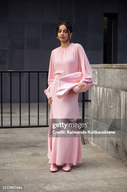 Banita Sandhu wears long pink silk dress and pink pouch bag outside Philosophy show during the Milan Fashion Week Menswear Spring/Summer 2025 on...