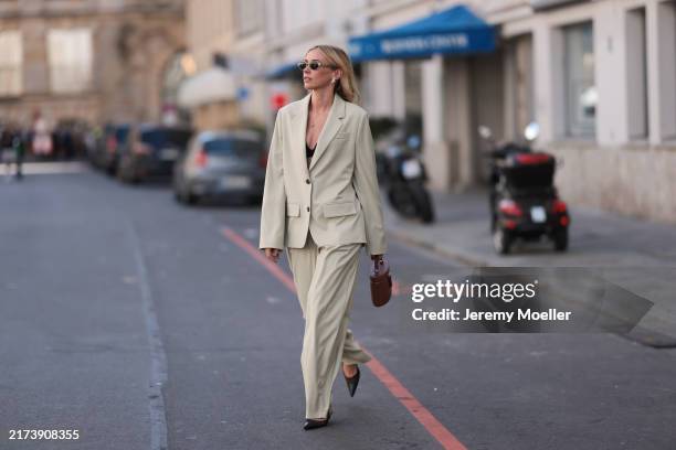 Jennifer Zimmermann is seen wearing oval sunglasses with a fine gold frame and wide temples from Celine; gold and diamond shooting star-shaped...