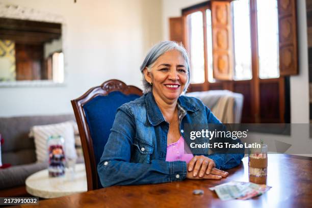 portrait of senior woman counting money at home - nafta stock pictures, royalty-free photos & images