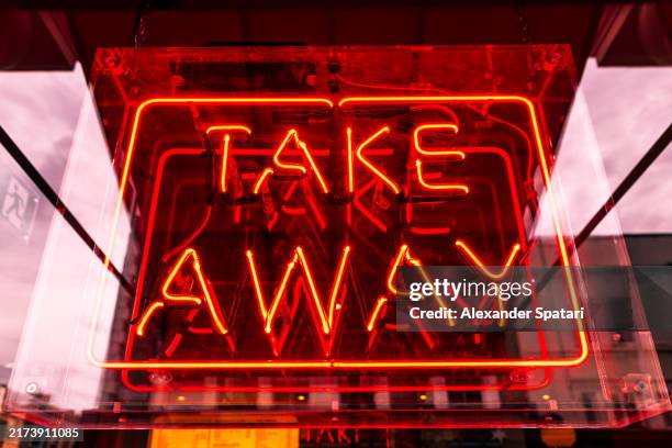 take away illuminated neon sign at the restaurant entrance - fast food restaurant stock pictures, royalty-free photos & images
