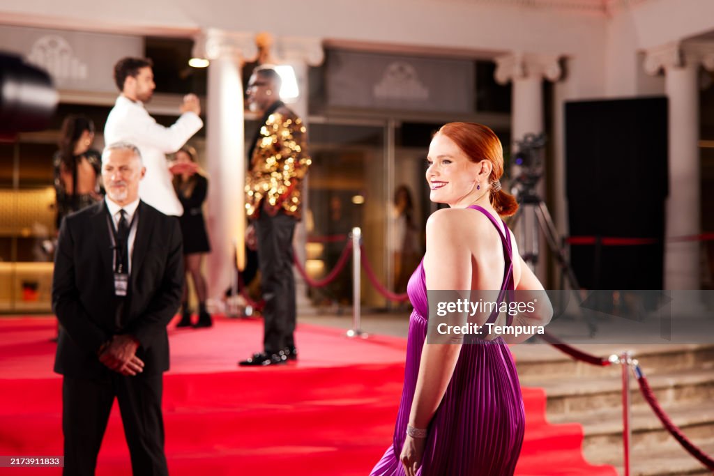 Als sie über den roten Teppich schreitet, lächelt die Schauspielerin die Paparazzi an.