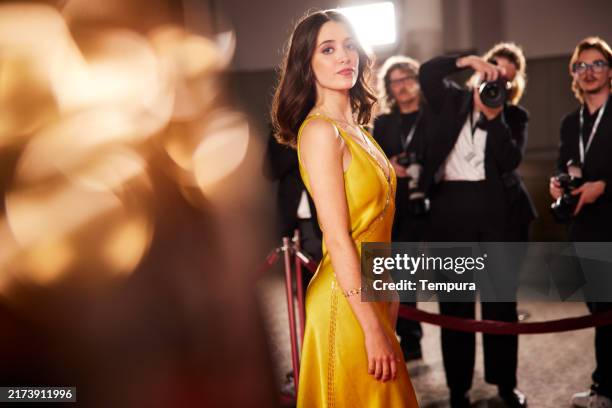 la jeune actrice pose pour la caméra en vue latérale, le regard dirigé vers l’objectif - actrice photos et images de collection